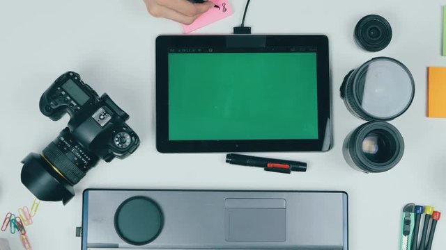 Photographer working with camera and laptop at his desk. View from above. 4K