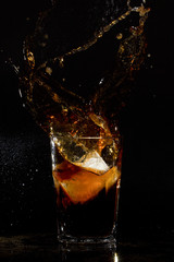Glass with cola and ice splash