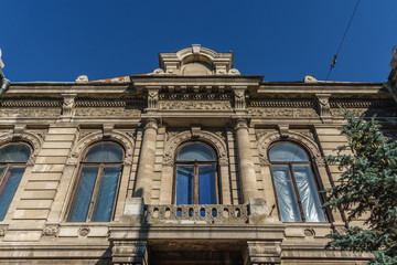Fototapeta na wymiar facade of the old stone house with windows and balcony