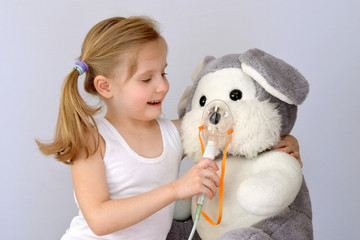 Child, kid (girl) with an inhaler (nebulizer) makes the procedure a soft toy. - obrazy, fototapety, plakaty