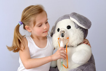 Child, kid (girl) with an inhaler (nebulizer) makes the procedure a soft toy.
