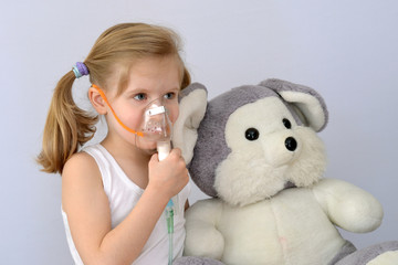 Child, kid (little girl) with inhaler (nebulizer) makes the procedure. - obrazy, fototapety, plakaty