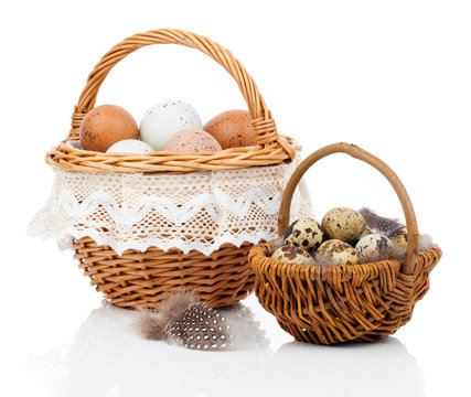 basket with eggs and quail eggs on a white background