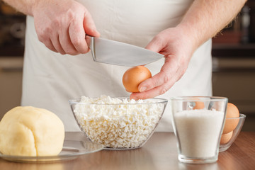 Obraz na płótnie Canvas Cook breaking an egg into the bowl