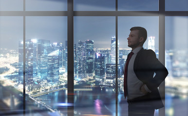 Man looking at night city through a window