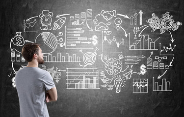 Man in T-shirt looking at chalk icons