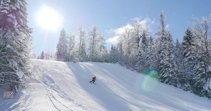 A beautiful winter scene with a skier skiing downhill