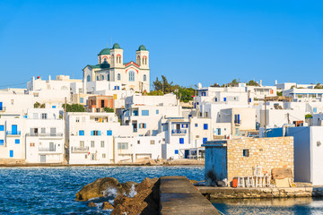 Traditional white houses and church in Naoussa port at sunset time, Paros island, Greece