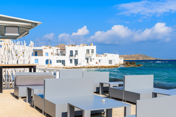 Obraz premium Taverna tables on beach in Naoussa fishing port, Paros island, Greece