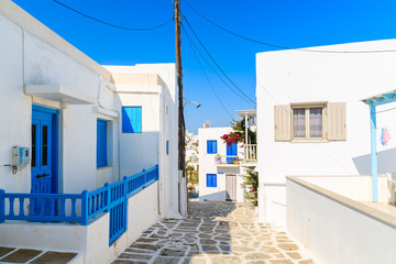Narrow street with typical white houses in Naoussa town, Paros island, Greece