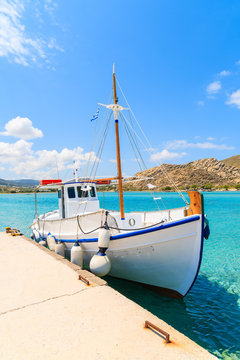 Typical Greek fishing boat mooring in secluded sea bay on Paros island, Greece