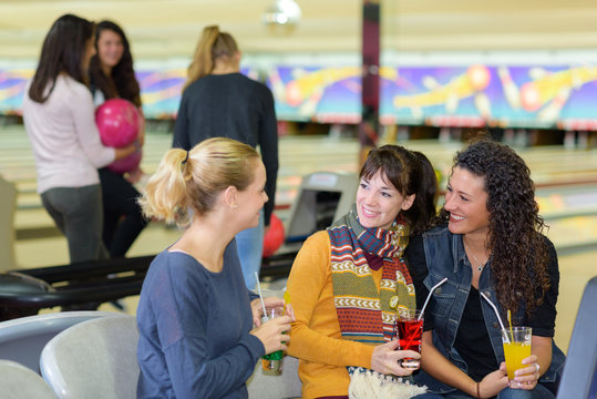 Women with drinks at bowling alley