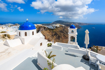 Fototapeta premium Błękitna kopuła kościół w Imerovigli wiosce i widok błękitny morze z kalderą na Santorini wyspie, Grecja
