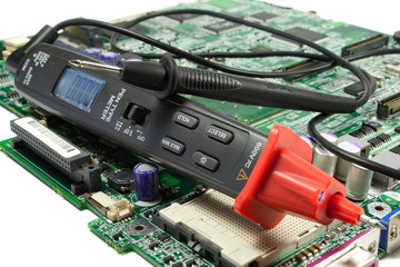 Fototapeta premium Digital multimeter pen type on the motherboard in a workshop