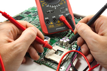 Digital multimeter with probe in the master's hands in a workshop