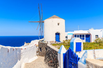 Fototapeta na wymiar Typical white windmill on street of Oia village, Santorini island, Greece