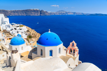 Fototapeta na wymiar Famous blue domes of white churches in Oia village on Santorini island, Greece