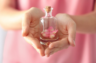 Woman holding bottle of aroma oil, closeup