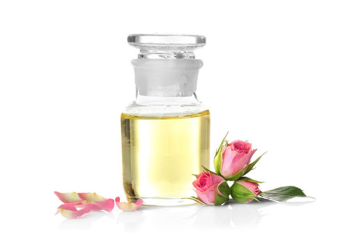 Bottle of aroma oil with roses on white background
