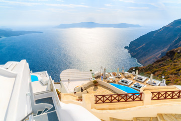 Obraz premium View of sea and and typical Greek boutique hotel with swimming pool in Imerovigli village, Santorini island, Greece