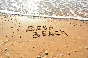 the inscription on the sand near the sea on a sunny day