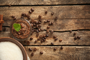 Coffee body scrub in glass bowl on wooden background
