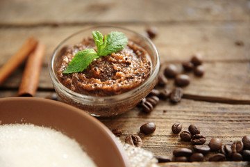 Coffee body scrub in glass bowl on wooden background