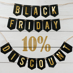 Black Friday ten percent Discount paper banner garland lettering hanging on white barn wood planks background. Luxurious holiday flyer.