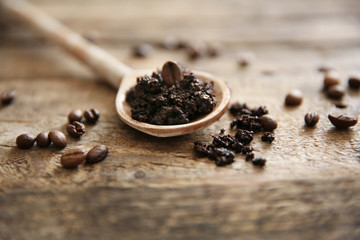 Coffee body scrub in spoon on wooden background