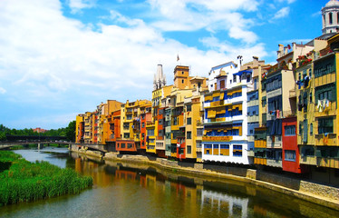 Colorful yellow and orange houses  reflected in water river , in Girona, Catalonia, Spain. Church Saint Mary Cathedral at background