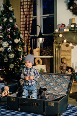 little boy in a suitcase in the Christmas decor, the child in the new year
