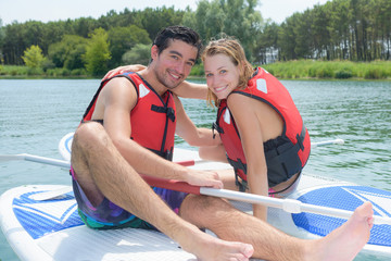 Obraz premium Couple embracing on paddle boards