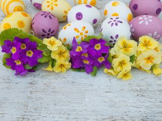 Easter eggs and yellow and violet primula flowers composition