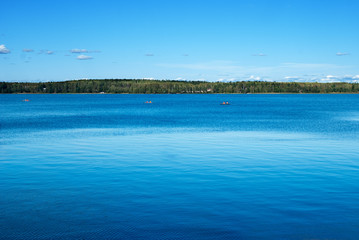 Landscape with the river in the sunny day. Water of deep blue color.