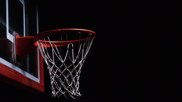 Close up of a basketball hitting the rim of the hoop and bouncing away