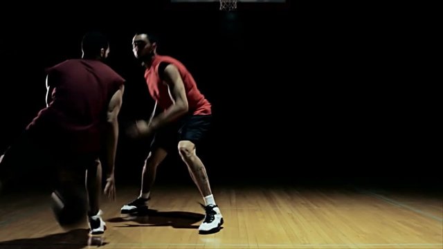 Two basketball players go one on one trying to score