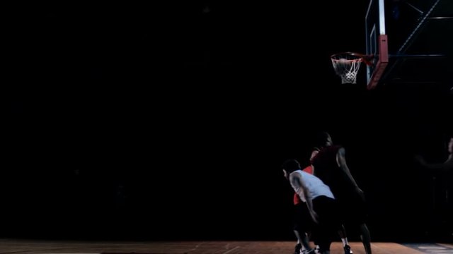 Basketball player passing the defensive players to make a layup shot.