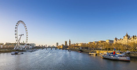 London skyline view at sunrise with famous landmarks, Big Ben, Houses of Parliament and ships on...