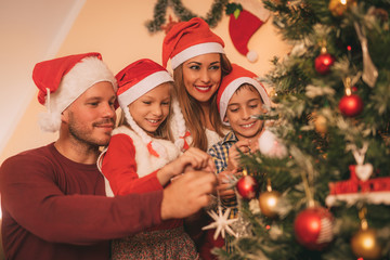 Obraz na płótnie Canvas Family Decorating Christmas Tree