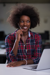 Fototapeta na wymiar black woman in modern office at her workplace speeking on phone