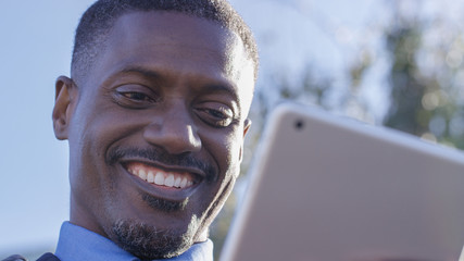 Handsome african american business man cheerfully using a digital tablet