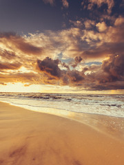 Beatiful sunset with clouds over sea and beach