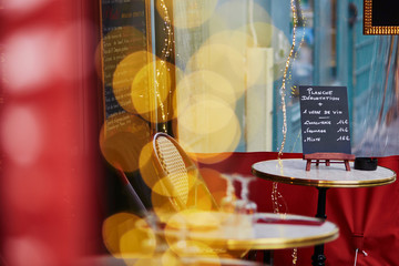 Cozy Parisian outdoor cafe with yellow lights and menu board on the table