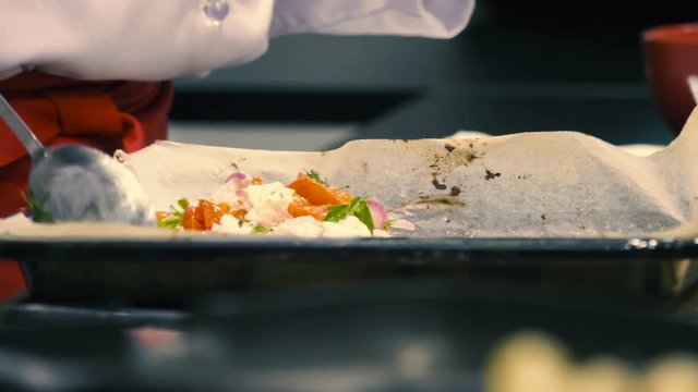 Cook mixes Greek salad on the restaurant's kitchen, hands close-up
