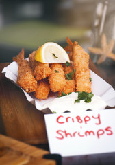 Tasty crispy fried shrimps with lemon and parsley with mayonnaise on a plate. Street food or unhealthy food concept