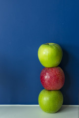 Arrangement of Red and green apples on blue background