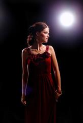 Fototapeta premium Young woman wearing a red dress standing