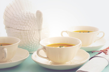 Fototapeta premium Traditional Thanksgiving pumpkin soup on pale blue table.