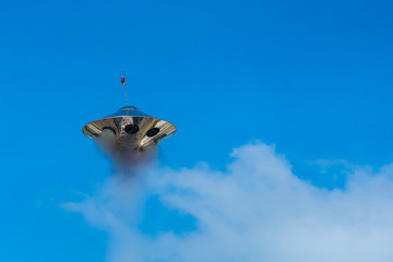 UFO and blue sky with white clouds.