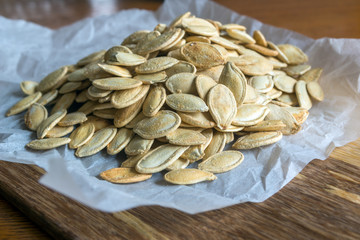 Grilled Pumpkin seeds with sea salt and spices on the wooden background